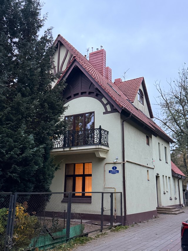 Светлый дом с высокой красной крышей
